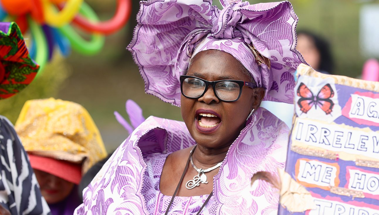 An older black woman dressed in purple
