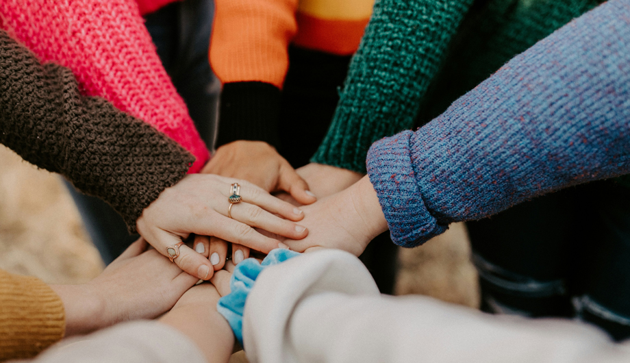 Multiple people putting their hands on top of each other